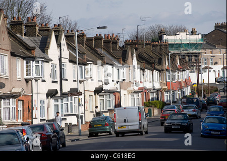 Verkehr und geparkte Autos auf einem Vorort Straße in Lewisham, London, England. Stockfoto