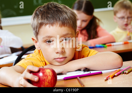 Nahaufnahme der Schüler, die er seinen Kopf auf den Arm und Blick in die Kamera Stockfoto