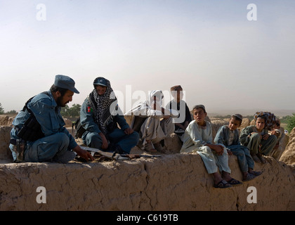 Mitglieder der afghanischen Nationalpolizei sprechen mit afghanischen Kindern während einer Räumungsaktion im Distrikt Khakrez, Provinz Kandahar, Afghanistan, 31. Mai 2011. Die Operation führte zur Entfernung von vier mutmaßlichen Aufständischen, sowie zur Ausbeutung von IED-Material und einer Waffenkontrolle. (USA Armeefoto von Sgt. Daniel P. schüttelte/entließ) Stockfoto