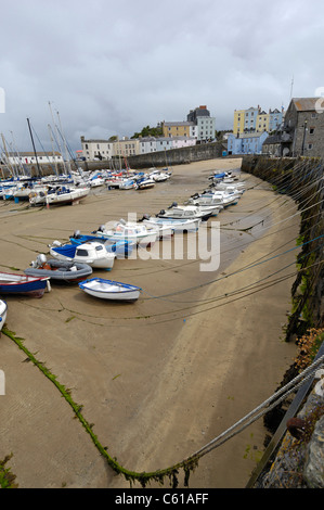 Kleine Boote gebundene zu Stein Hafen-Meer-Verteidigung in Tenby in Wales bei Ebbe. Stockfoto