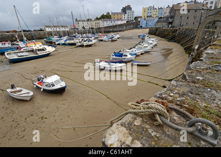 Kleine Boote gebundene zu Stein Hafen-Meer-Verteidigung in Tenby in Wales bei Ebbe. Stockfoto