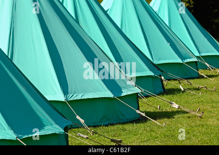 Eine Reihe von grünen Glocke Zelten aus schweren Leinwand und auf den Boden durch verstellbare Reiseführer Seilen gesichert. Stockfoto