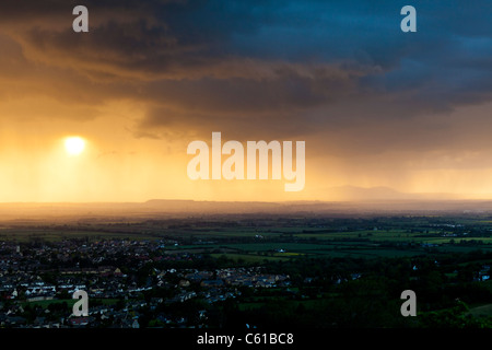 Die Aussicht vom Cleeve Hill - ein Sturm in der Abenddämmerung nähert sich Bishops Cleeve, Gloucestershire - Malvern Hills im Hintergrund. Stockfoto