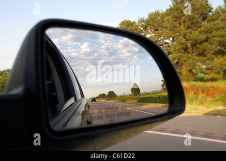 Auto Seite Außenspiegel mit bewölktem Himmel während der Fahrt entlang einer Autobahn in den usa Stockfoto