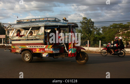 Passagiere auf Dreirad taxi am Sonnenuntergang Pakse Laos Stockfoto