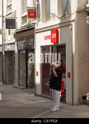 Mann mit seinem neuen Handy vor dem SFR Shop in Blois, Loiretal, Frankreich Stockfoto