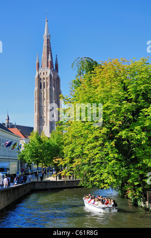 Brügge / Brugge, Flandern, Belgien. Onze-Lieve-Vrouwkerk / Liebfrauenkirche und touristischen Kanalboot Stockfoto