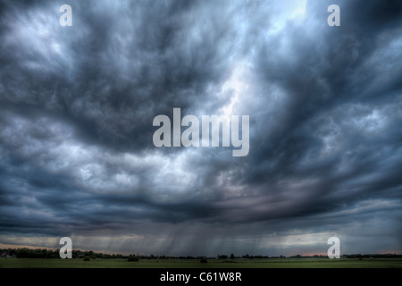 Ein Sommergewitter über entfernte Felder regnen. Stockfoto