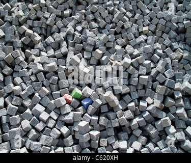 RGB-Konzept: Drei farbige Granitwürfel (rote, grüne & blau) unter einer Sammlung von grauen Granit-Sets. Stockfoto