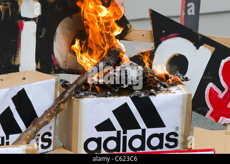 Demonstranten zündeten, Adidas Logos und Boxen zu protestieren gegen Adidas Preise für alle schwarz-Rugby-Shirts zu verspotten Stockfoto