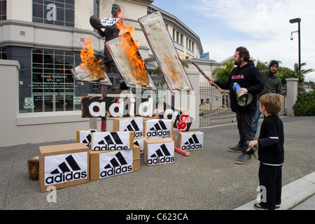 Demonstranten zündeten, Adidas Logos und Boxen zu protestieren gegen Adidas Preise für alle schwarz-Rugby-Shirts zu verspotten Stockfoto