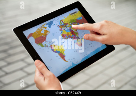 Eine Frau, die Anwendung mit Weltkarte auf Apple Ipad2 Stockfoto