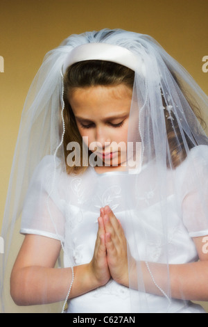 Kind beten im ersten Heiligen Kommunion Kleid Stockfoto