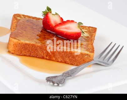 French Toast und Sirup mit Erdbeeren, isoliert auf weiss mit Gabel. Stockfoto