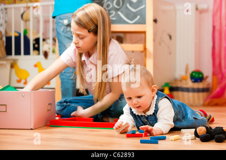 Kinder - Schwestern - spielen zu Hause; ein Kind ist noch ein baby Stockfoto