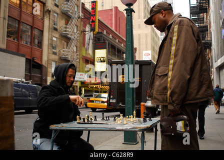 UPS-Bote spielt eine Partie Schach mit einem anderen Mann auf dem Bürgersteig in Midtown Manhattan, New York City. © Craig M. Eisenberg Stockfoto