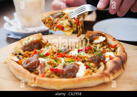 Ein Mann, ein Stück frisch zubereitete Pizza in einem Café serviert. Stockfoto