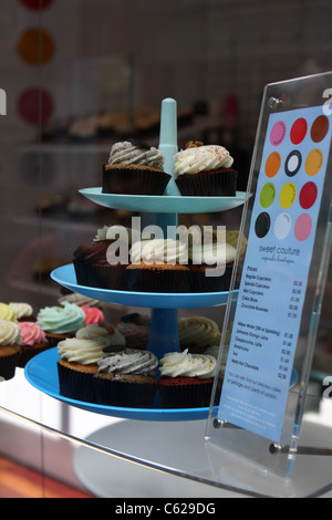 Cup Cakes auf einem Ständer im Fenster eine Konditorei neben einer Preisliste Stockfoto