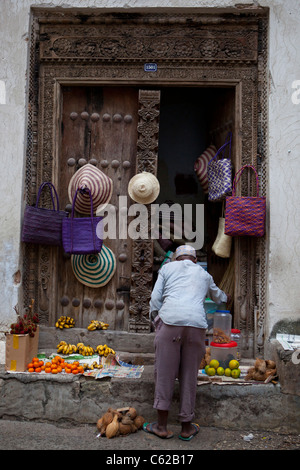 Ein Mann an seinem vorderen Strassenlokal in Stonetown, Zanzibar. Stockfoto