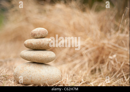 Stapel von ausgewogenen Felsen Hintergrund braun Rasen Stockfoto