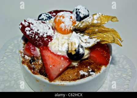 Heißer Apfelkuchen gemischte Beeren Gelato Richtfest Puderzucker in weißem Porzellanschüssel Stockfoto