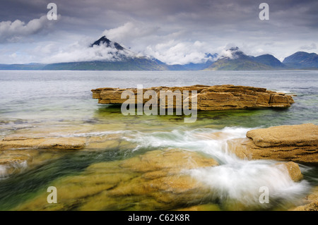 Wirbelnde Wellen an Elgol auf der Isle Of Skye mit Wolke gehüllt Black Cuillin Berge im Hintergrund Stockfoto