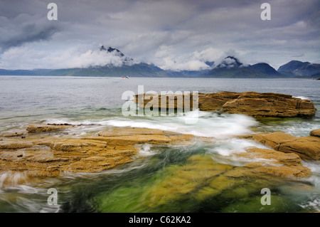 Wirbelnde Wellen an Elgol auf der Isle Of Skye mit Wolke gehüllt Black Cuillin Berge im Hintergrund Stockfoto