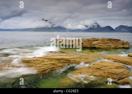 Wirbelnde Wellen an Elgol auf der Isle Of Skye mit Wolke gehüllt Black Cuillin Berge im Hintergrund Stockfoto