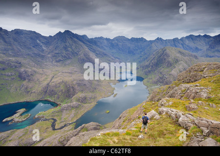 Männliche Walker, genießen Sie den Blick über Loch Coruisk auf den zerklüfteten Grat der Black Cuillin Berge, Isle Of Skye, Schottland Stockfoto