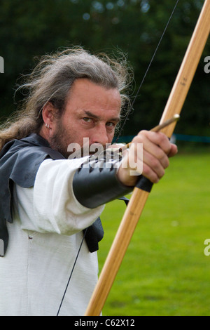 Bogenschütze mit Lemonwood und Hickory Langbögen, englischem Langbogen und Pfeilen, Waffe, Genauigkeit, Konzentrat, Kämpfer, Ziel, Ziel, Sport, schießen, jagen, Ziel, Präzision, Vektor, Bogenschützen beim Northwich Medieval Festival Verdin Park, Cheshire13.. August 2011 - 14.. August 2011, Großbritannien Stockfoto