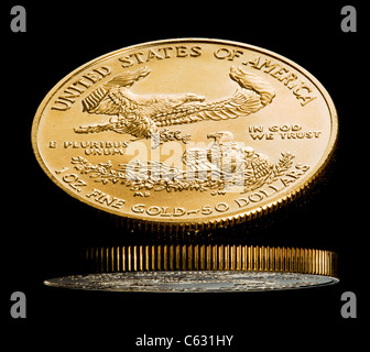 Nahaufnahme einer solid gold Eagle 1 Unze Münze in schwarz glänzende Oberfläche reflektiert Stockfoto