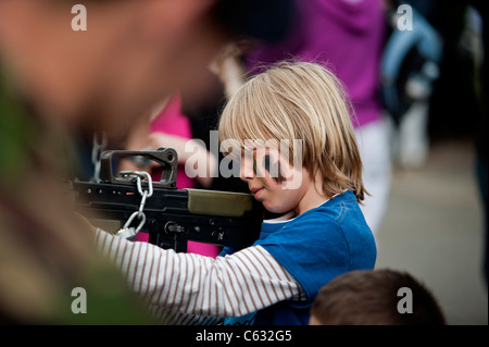 Ein Junge mit einem Gewehr auf eine Armee stand. Eastbourne, East Sussex. England, Großbritannien Stockfoto