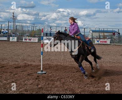 Diese Teen Cowgirl ist Pol racing auf ein schwarzes Pferd bei einem Rodeo am 16. April 2010 im Coulee City, Grant County, Washington. Stockfoto