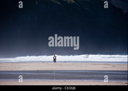 Menschen amüsieren sich ein Hund am Strand von Perranporth, ein beliebter Ferienort in Cornwall Stockfoto