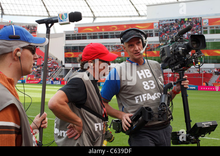 Steadicam-Bediener und Sound man warten darauf, dass die Nationalmannschaften aus Japan und Mexiko das Feld für ein Fußball-Spiel der FIFA Frauen-Weltmeisterschaft erobern. Stockfoto