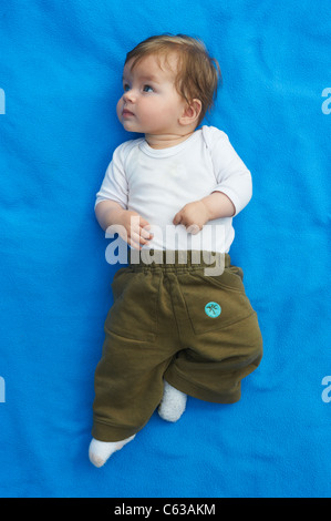 Kleines Mädchen auf blaue Decke Gras außen liegend Stockfoto