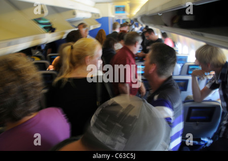 Die Fluggäste platzieren oder Entfernen von Handgepäck in die Gepäckfächer Stockfoto