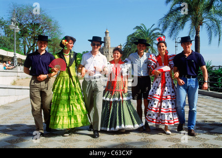 Junge Männer und Frauen mit bunten Trachten "Feria De Sevilla" Festivals in Sevilla (Sevilla), Spanien Stockfoto