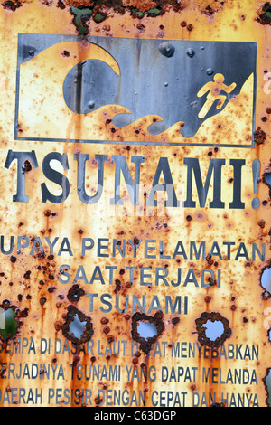 Rosten Tsunami-Evakuierung Warnzeichen am Sekongkang Strand in Nusa Tenggara, Indonesien. Stockfoto