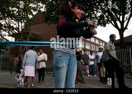 Clarence Straße Hackney. Straßenfest Tee eine Woche nach den Unruhen. Junge Mädchen spielen mit einem Hula-Hoop vor Anwesen Stockfoto