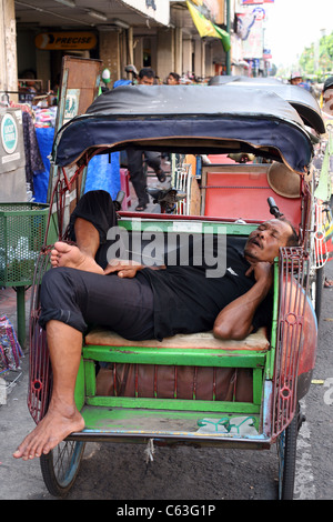 Mann schläft in seinem Rikscha auf Jalan Malioboro Stockfoto