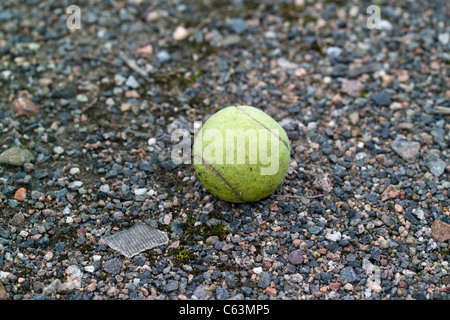 Tennisball auf Schotter Stockfoto