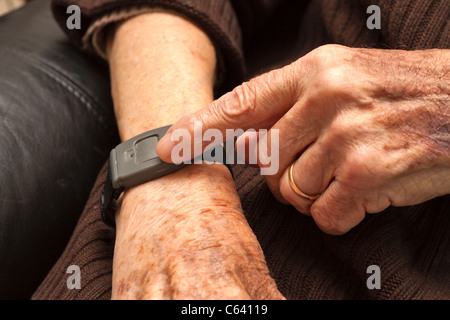 Senioren mit einer medizinischen Alarm alarm-System auf ein Armband. Stockfoto