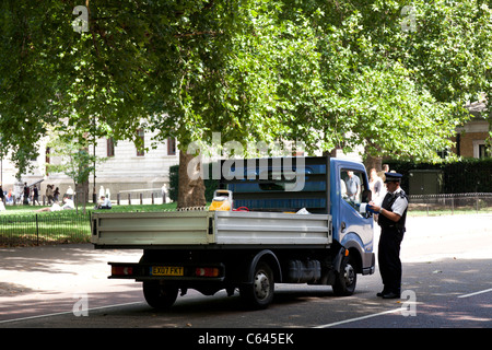 Polizist Buchung falsch geparktes des Arbeiters Fahrzeug auf Birdcage Walk London Stockfoto