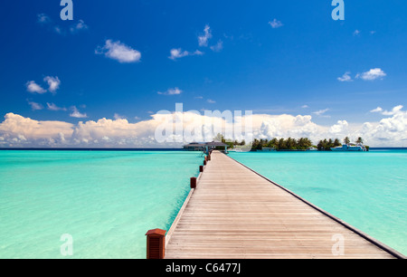 Fußgängerbrücke über türkisblaue Meer auf einer maledivischen Insel Stockfoto