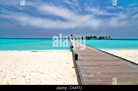 Fußgängerbrücke über türkisblaue Meer auf einer maledivischen Insel Stockfoto