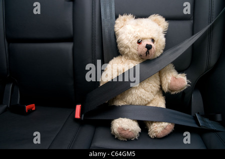 Teddybär mit Sicherheitsgurt im Auto angeschnallt Stockfoto