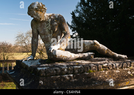 Die mit Flechten bedeckte Statue des 'ding Gladiator' von Scheemaker, gebadet in warmen Wintersonnenstrahlen im Rousham House, Oxfordshire, England Stockfoto