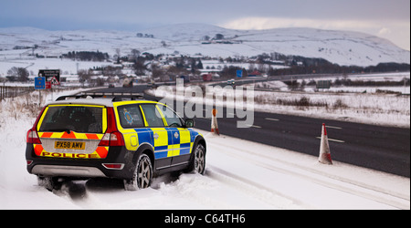 Polizeifahrzeug auf Autobahn-Patrouille im Winterschnee. UK Stockfoto