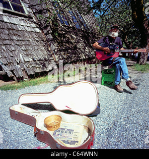 Hippie-Straßenmusikant Straßenmusikant Gitarre für Tipps, Coombs, BC, in der Nähe von Parksville, Vancouver Island, British Columbia, Kanada Stockfoto